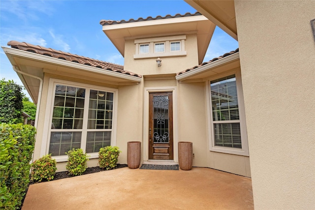 5916 River Highlands Dr, Mckinney, TX 75070 - view of exterior entry featuring a patio, a tile roof, and stucco siding