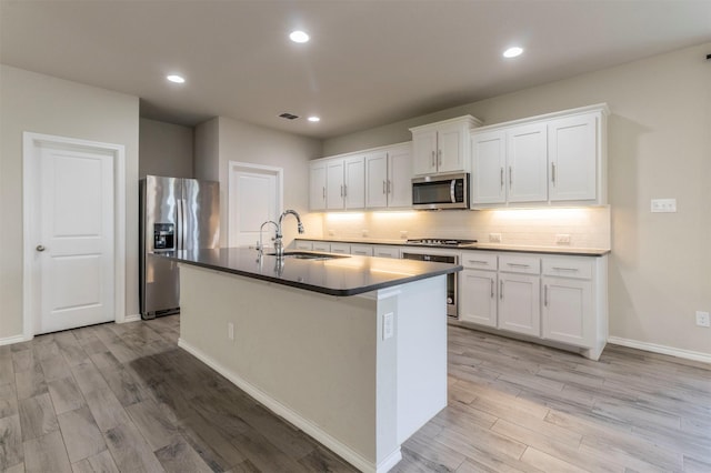 1800 Emilia Dr, Celina, TX 75009 - kitchen featuring stainless steel appliances, a sink, light wood-style flooring, a center island with sink, and tasteful backsplash
