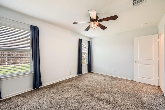 unfurnished room with visible vents, carpet, ceiling fan, and baseboards
