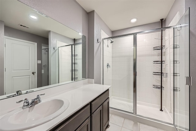 full bath featuring vanity, a shower stall, tile patterned floors, and visible vents