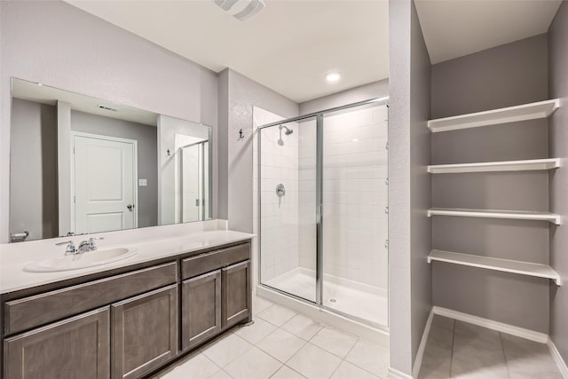 full bathroom featuring tile patterned flooring, vanity, visible vents, baseboards, and a shower stall