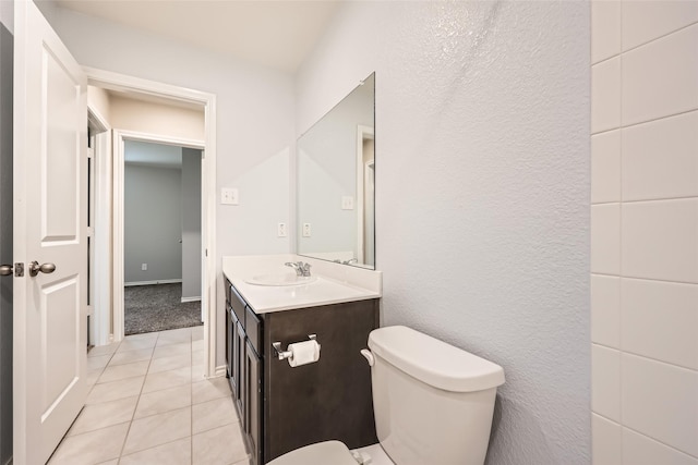 bathroom with toilet, tile patterned floors, and vanity