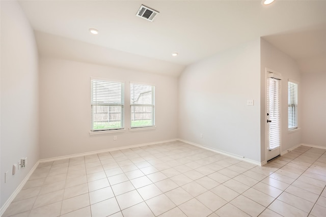 empty room featuring light tile patterned flooring, recessed lighting, baseboards, lofted ceiling, and visible vents