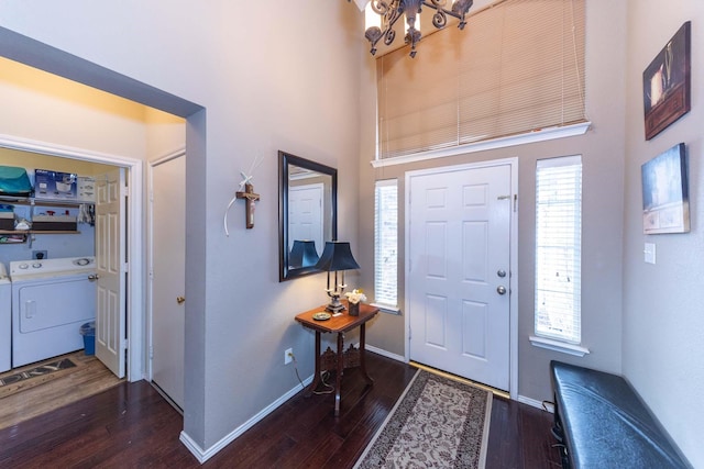 foyer entrance featuring plenty of natural light, a chandelier, wood finished floors, and washer and dryer