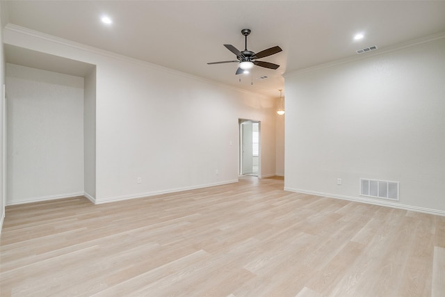 empty room featuring visible vents, ornamental molding, ceiling fan, and light wood-type flooring