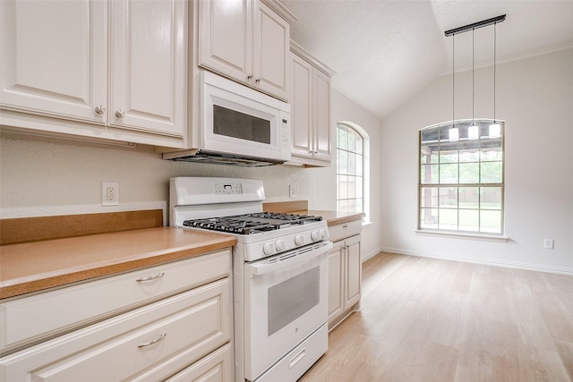 kitchen with lofted ceiling, white appliances, light countertops, light wood-style flooring, and decorative light fixtures