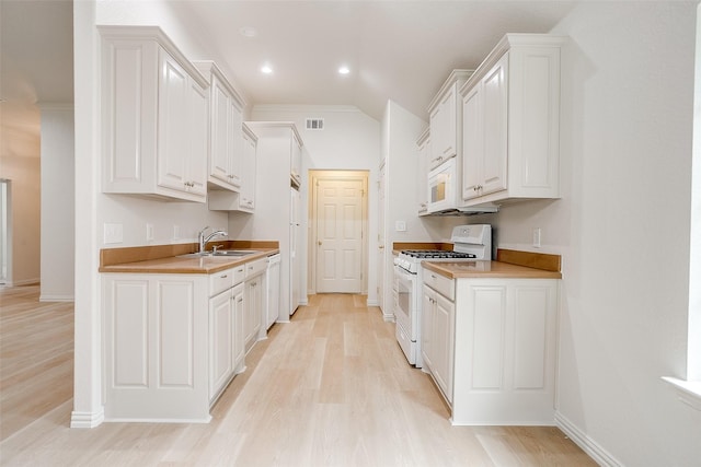kitchen with light wood-style floors, white cabinetry, and white appliances