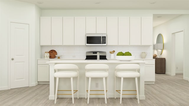 kitchen with light countertops, decorative backsplash, stainless steel microwave, and range