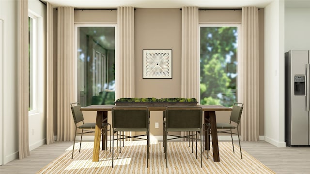 dining space featuring baseboards and wood finished floors