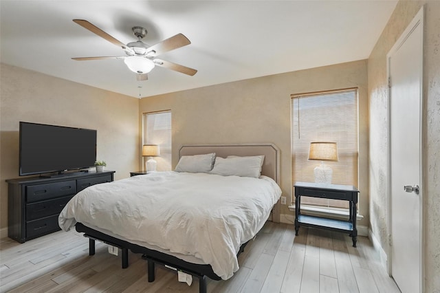 bedroom with baseboards, ceiling fan, and light wood finished floors