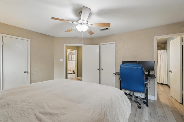 bedroom featuring ceiling fan, visible vents, and light wood-type flooring