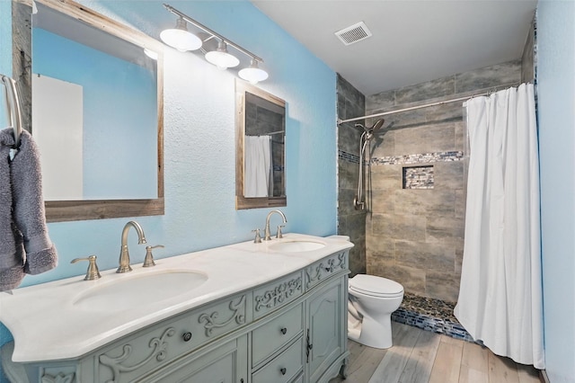 bathroom featuring a sink, toilet, double vanity, and visible vents