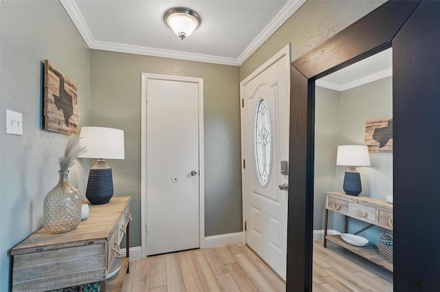 foyer featuring baseboards, ornamental molding, and wood finished floors