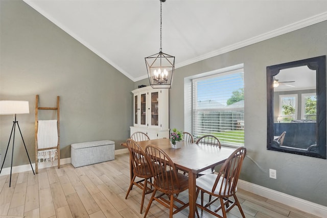 dining area with crown molding, an inviting chandelier, light wood-style flooring, baseboards, and lofted ceiling
