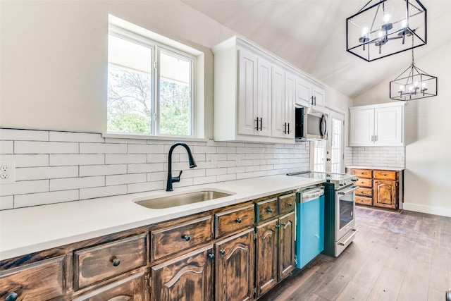 2223 Foxcroft Cir, Denton, TX 76209 - kitchen with decorative backsplash, appliances with stainless steel finishes, a sink, light countertops, and an inviting chandelier