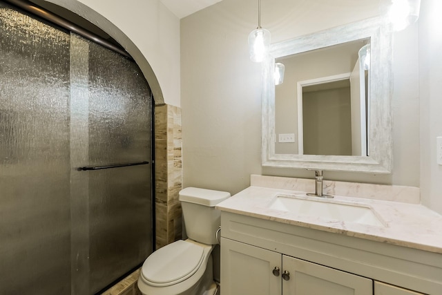 bathroom featuring toilet, a shower stall, and vanity