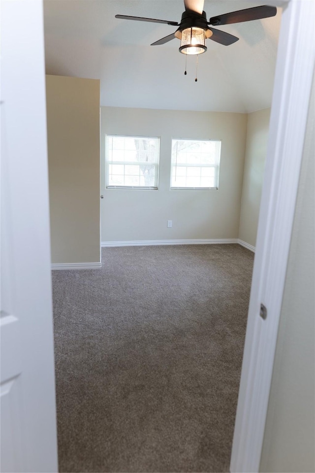 empty room with carpet floors, a ceiling fan, baseboards, and a wealth of natural light
