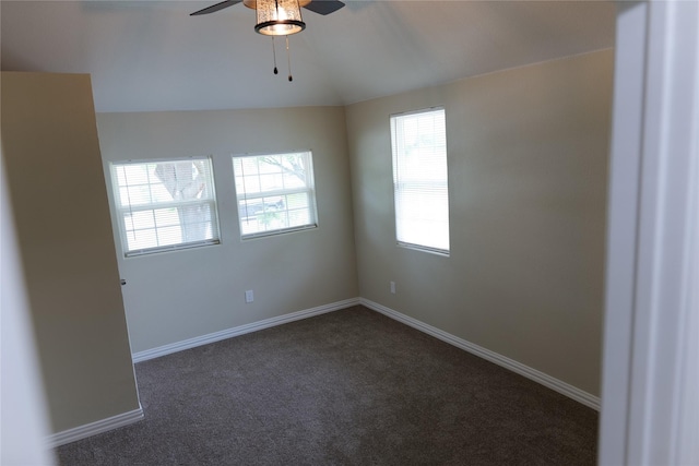 spare room with baseboards, ceiling fan, dark carpet, and lofted ceiling