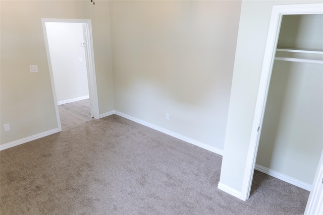unfurnished bedroom featuring a closet, baseboards, and carpet flooring