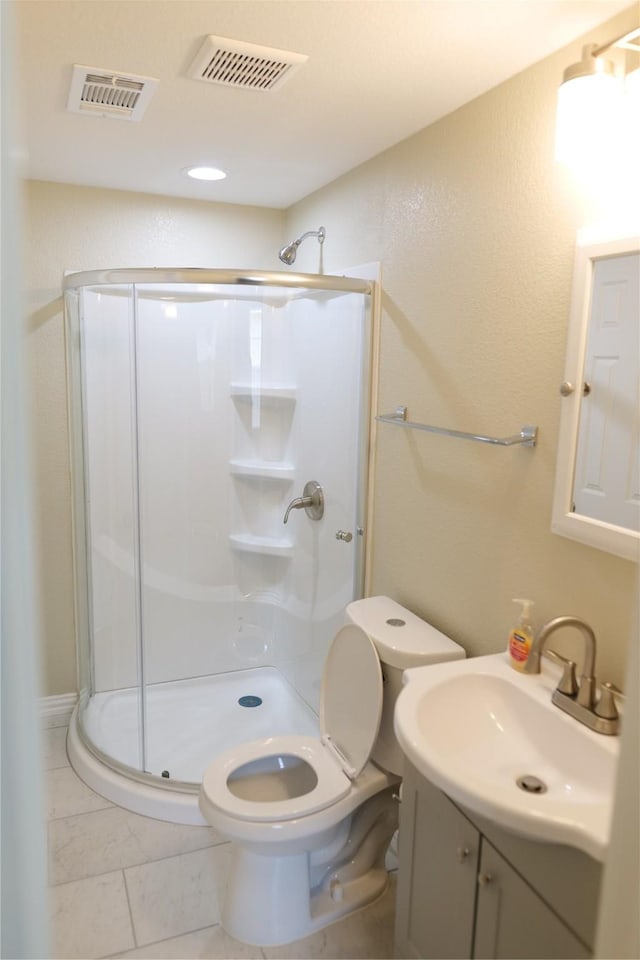 bathroom with vanity, a shower stall, toilet, and visible vents