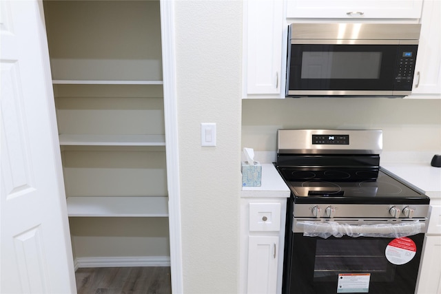 kitchen featuring light countertops, appliances with stainless steel finishes, and white cabinetry