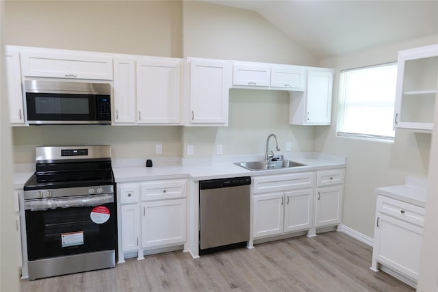 kitchen with white cabinets, stainless steel appliances, a sink, and light wood finished floors