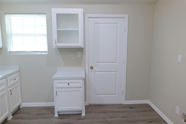 interior space featuring vanity, baseboards, and wood finished floors