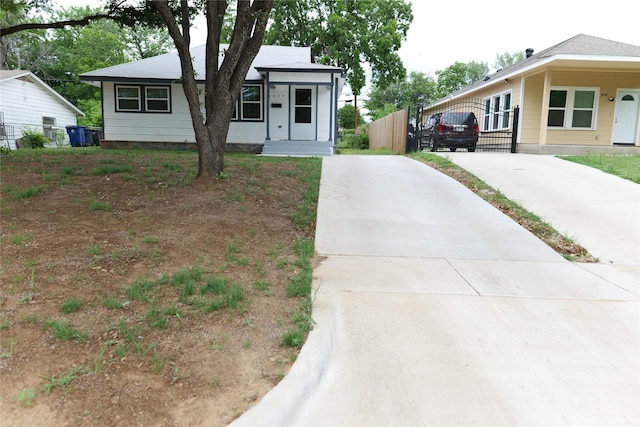 view of front of property with a gate, fence, and concrete driveway