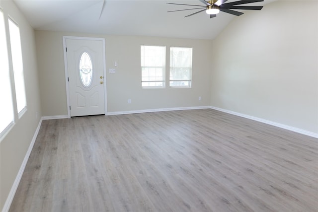 foyer featuring baseboards, ceiling fan, wood finished floors, and vaulted ceiling