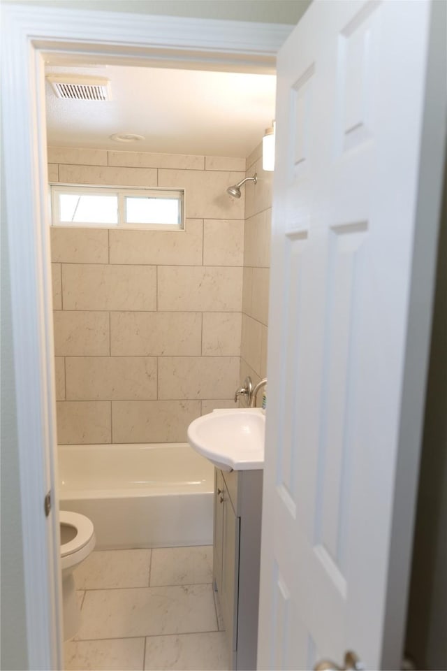 bathroom with visible vents, vanity, marble finish floor, bathing tub / shower combination, and toilet