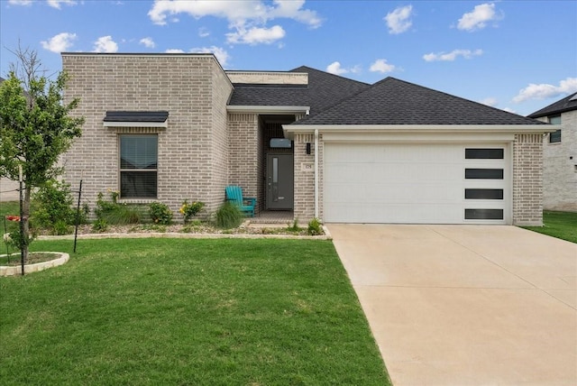 modern home featuring roof with shingles, brick siding, a garage, a front yard, and driveway