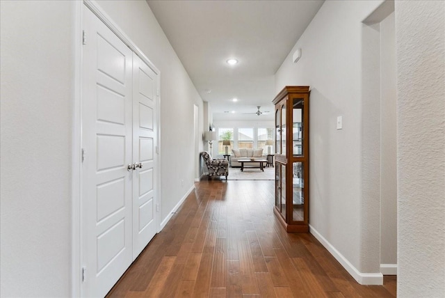 corridor with recessed lighting, baseboards, and dark wood-style floors