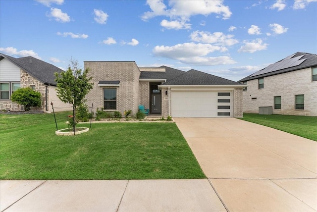 view of front of property with brick siding, a garage, a front lawn, and driveway