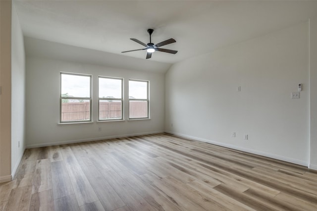 unfurnished room featuring a ceiling fan, baseboards, and light wood-style flooring