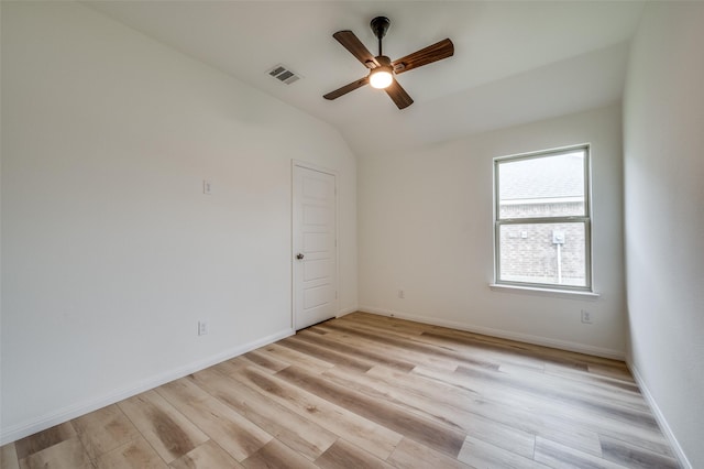 spare room with ceiling fan, baseboards, vaulted ceiling, light wood-type flooring, and visible vents