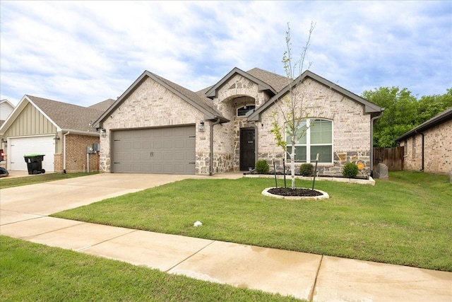 french country inspired facade with a garage, a front yard, stone siding, and concrete driveway
