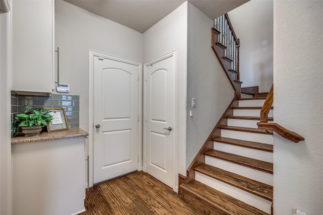 217 Brick Row Dr, Richardson, TX 75081 - staircase with a textured wall and wood finished floors