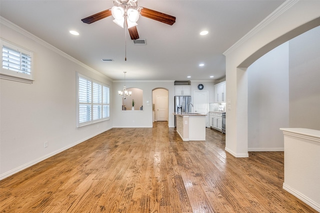 217 Brick Row Dr, Richardson, TX 75081 - unfurnished living room featuring visible vents, arched walkways, light wood-style flooring, and ceiling fan with notable chandelier