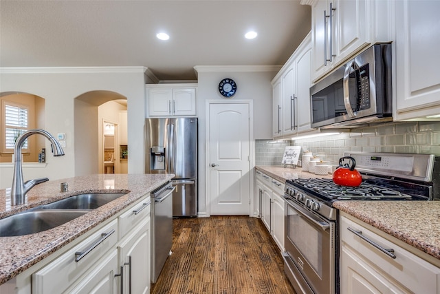 217 Brick Row Dr, Richardson, TX 75081 - kitchen featuring arched walkways, a sink, ornamental molding, stainless steel appliances, and white cabinetry