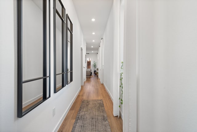 hall with recessed lighting, baseboards, and light wood-style floors