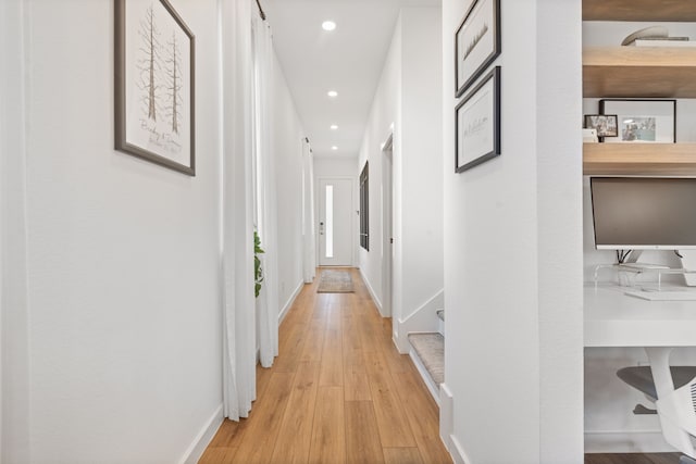 hall with baseboards, light wood finished floors, and recessed lighting