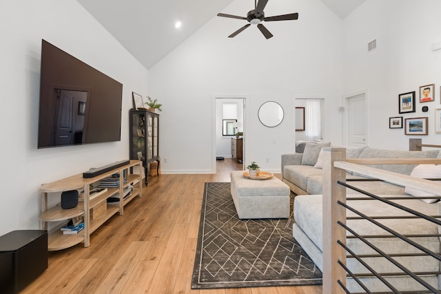living area with high vaulted ceiling, a ceiling fan, baseboards, light wood-type flooring, and visible vents