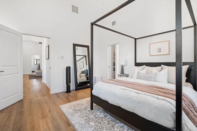 bedroom with baseboards, light wood finished floors, and visible vents