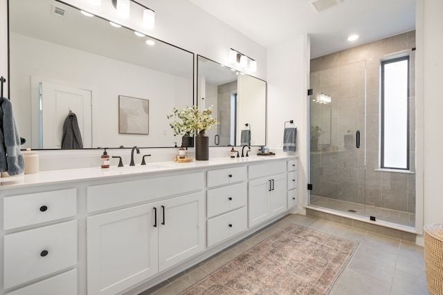 bathroom with a sink, a shower stall, and a healthy amount of sunlight