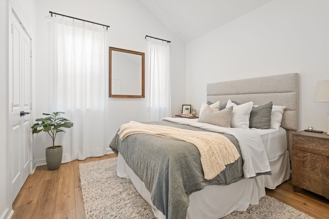 bedroom featuring light wood-style floors and lofted ceiling