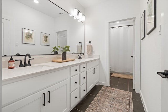full bathroom featuring double vanity, toilet, a sink, and tile patterned flooring