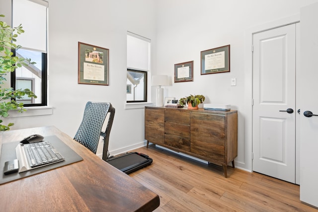 office area with baseboards and light wood finished floors