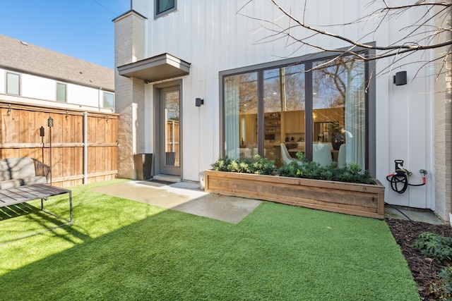 back of house featuring a lawn and fence