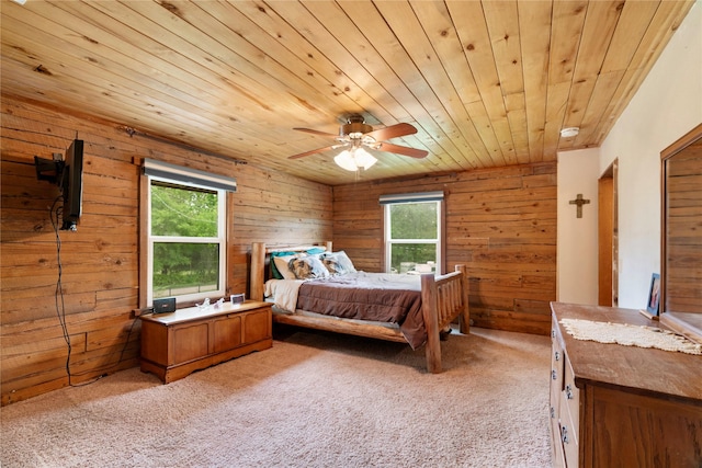 bedroom with wooden ceiling, light carpet, a ceiling fan, and wood walls