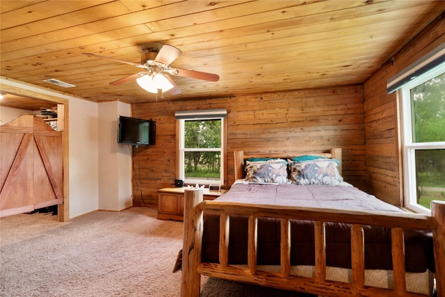bedroom with wooden walls, wooden ceiling, light carpet, and visible vents